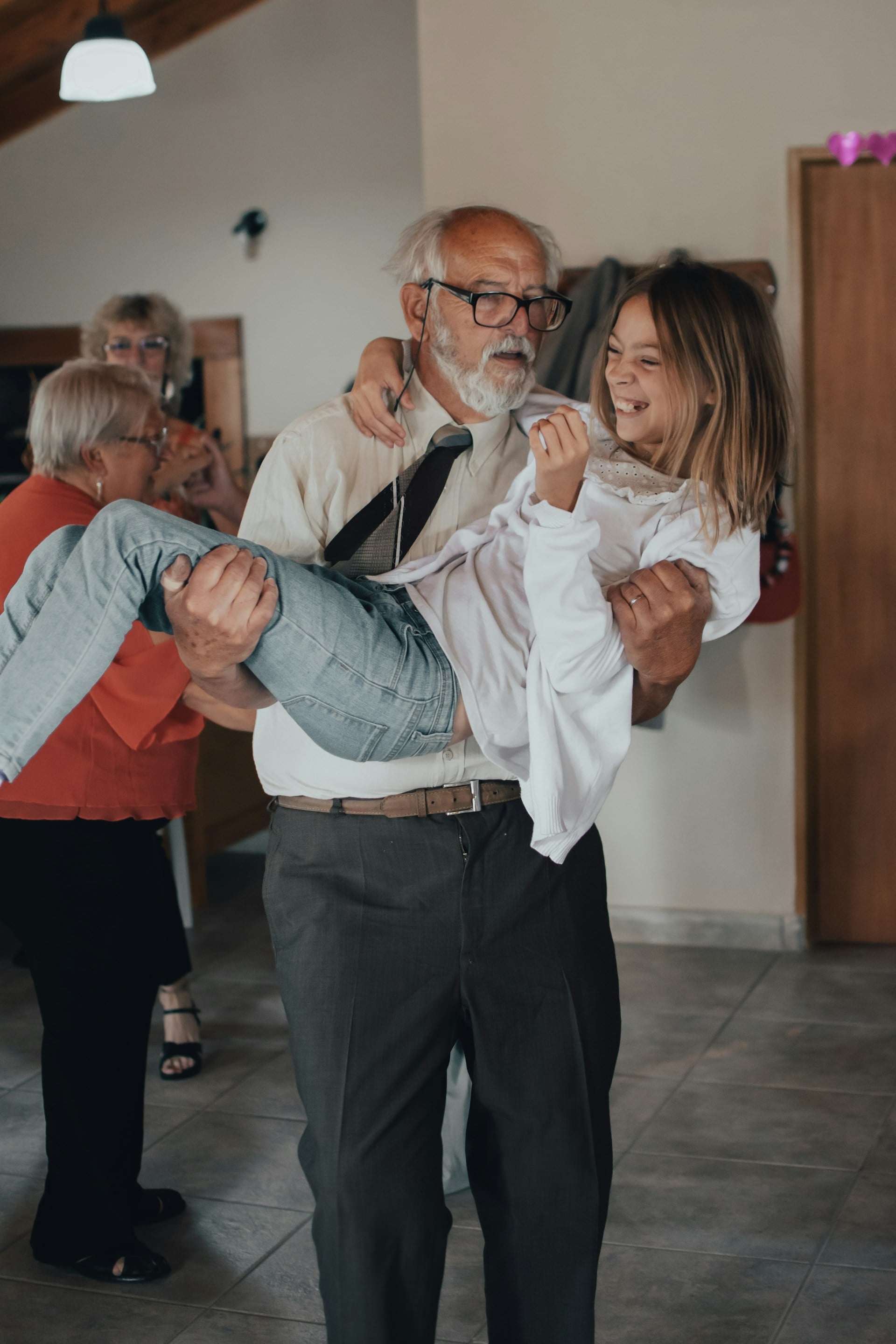 Grandfather holding granddaughter at dance